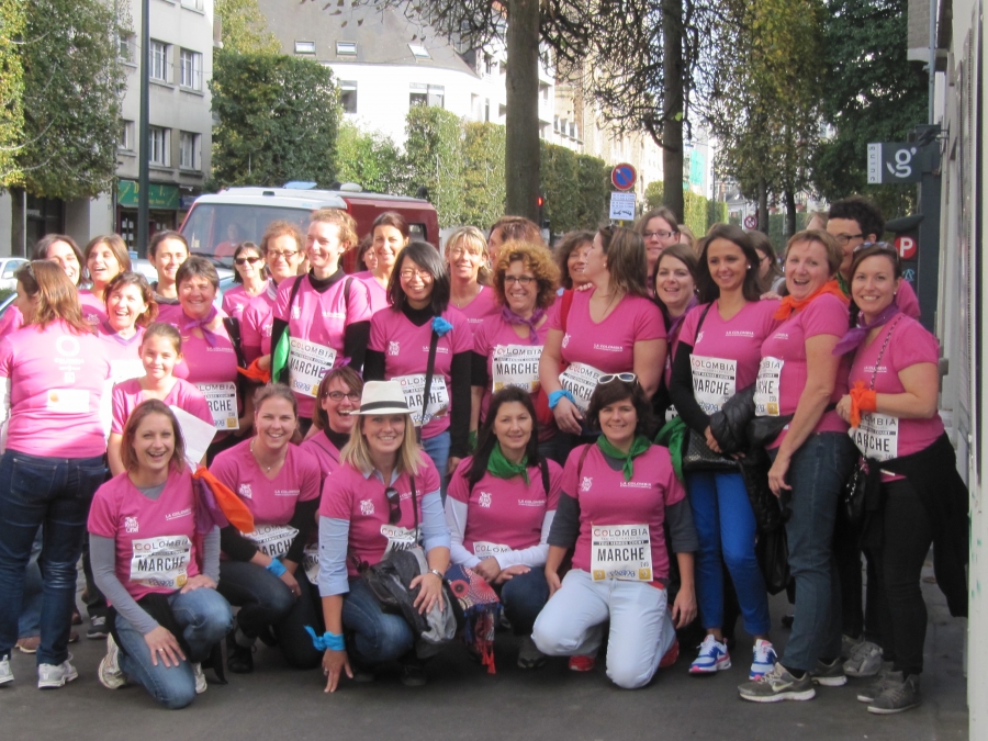 Groupe de participantes portant des tee-shirts roses lors d’une marche organisée en ville.