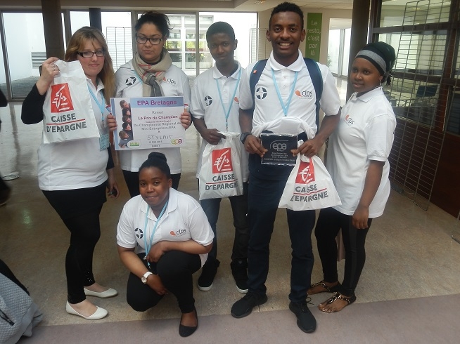 Groupe de six personnes posant avec un panneau de récompense et des sacs promotionnels.