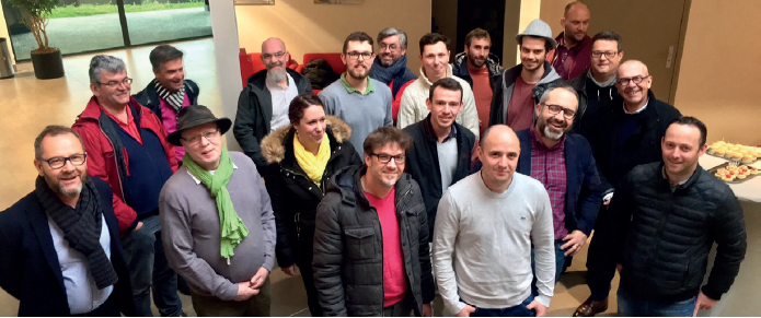 Groupe de personnes posant dans un hall intérieur. Les participants sont rassemblés pour une photo de groupe, certains au premier plan et d'autres en arrière-plan.