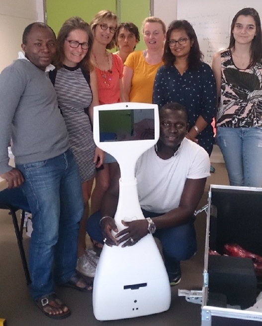 Groupe de stagiaires rassemblés autour d’un robot de téléprésence blanc dans une salle de formation.