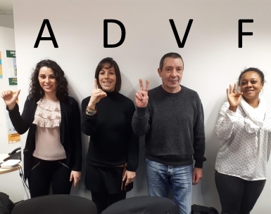 Quatre personnes posent devant un mur blanc sur lequel figurent les lettres « A D V F ».
