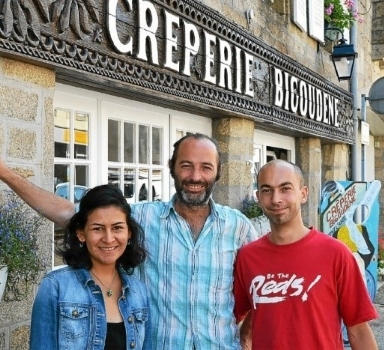 Trois personnes se tiennent devant la façade d'une crêperie. L'enseigne « Crêperie Bigoudène » est visible au-dessus de l'entrée.