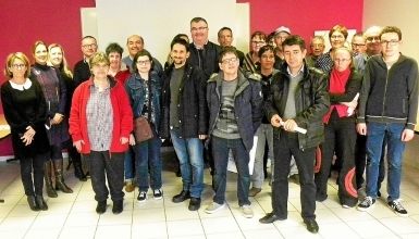 Groupe d'une vingtaine de personnes réuni dans une salle lors d'une cérémonie de remise de diplômes ou de certifications.
