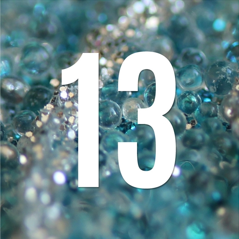 Nombre 13 blanc sur fond bleu composé de perles translucides et de paillettes scintillantes.
