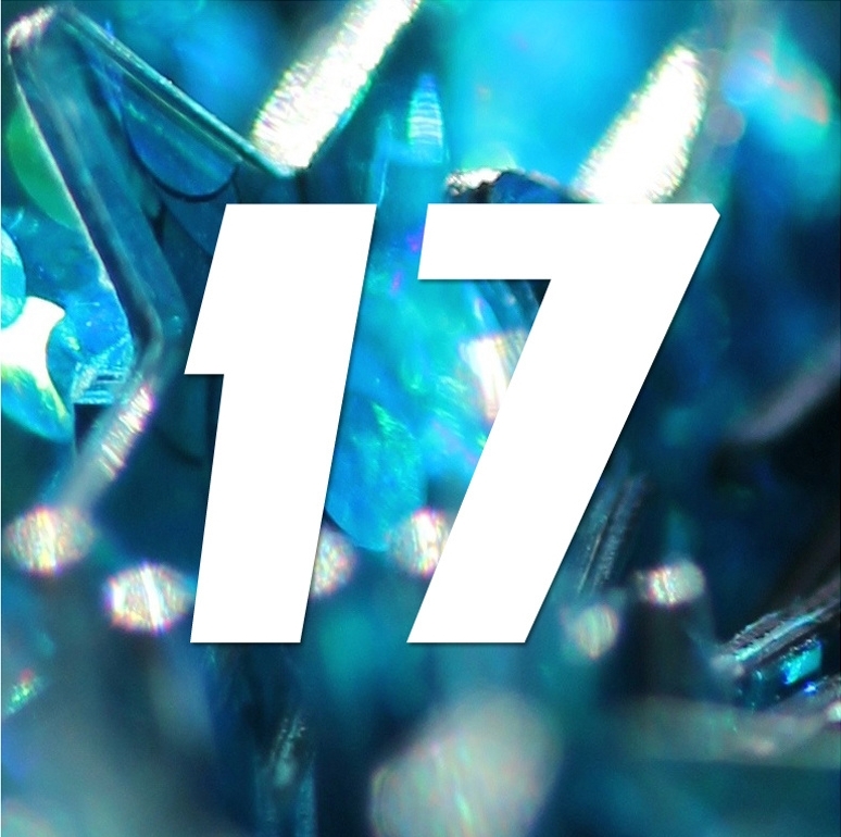 Nombre 17 blanc sur fond bleu composé d'éléments brillants et translucides.