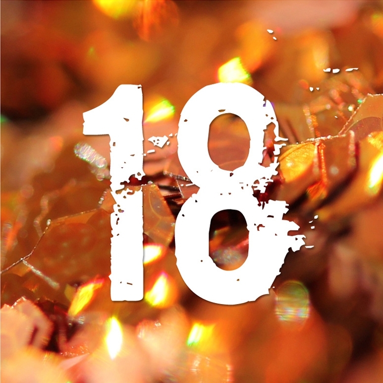 Nombre 18 blanc sur fond orange et doré composé d'éléments scintillants.